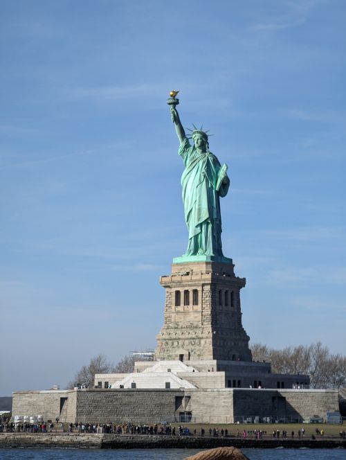 Free Iconic Statue of Liberty with clear blue sky on Liberty Island, New York City. Stock Photo