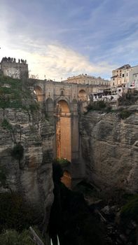 Dramatic view of Puente Nuevo spanning the gorge in Ronda, Spain at sunset.