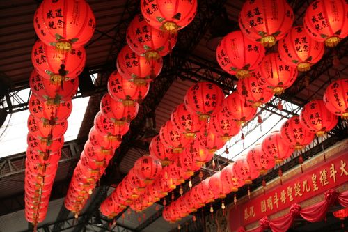 Free Red Chinese lanterns with calligraphy hanging indoors, creating a festive atmosphere. Stock Photo