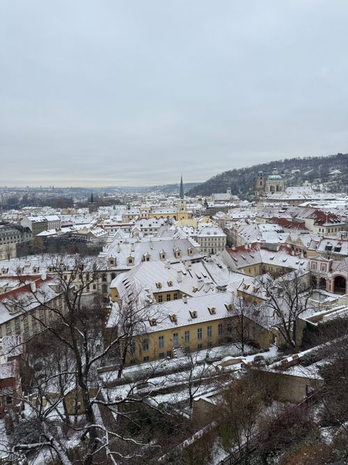 Free Aerial view of snow-covered historic Prague cityscape during winter, showcasing classic architecture. Stock Photo