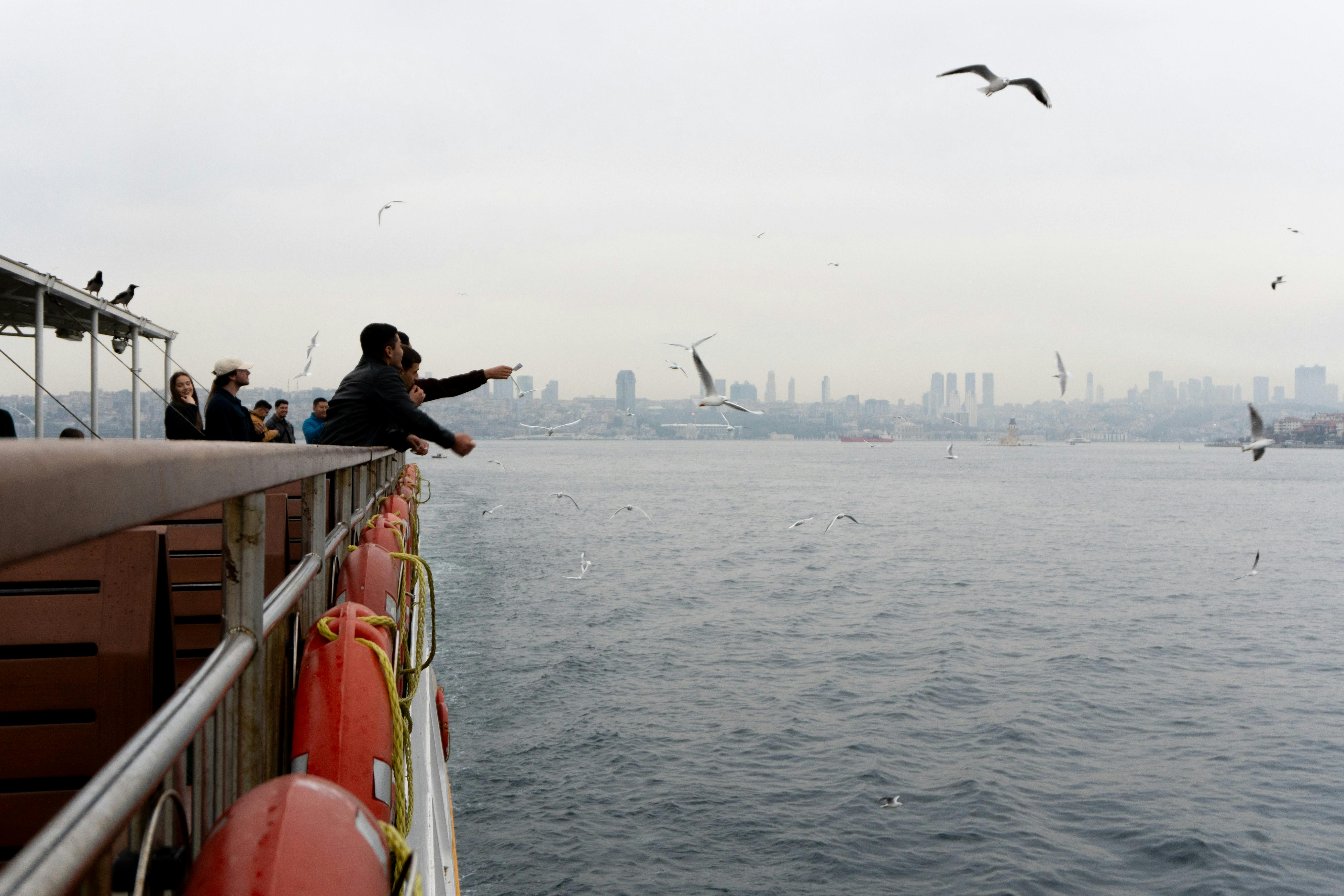 The iconic orange Magic Carpet cantilevered off the side of a Celebrity Edge Class ship, viewed against a deep blue sea and sky.
