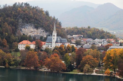 Free Autumn landscape of Bled with church, lake, and colorful trees. Stock Photo