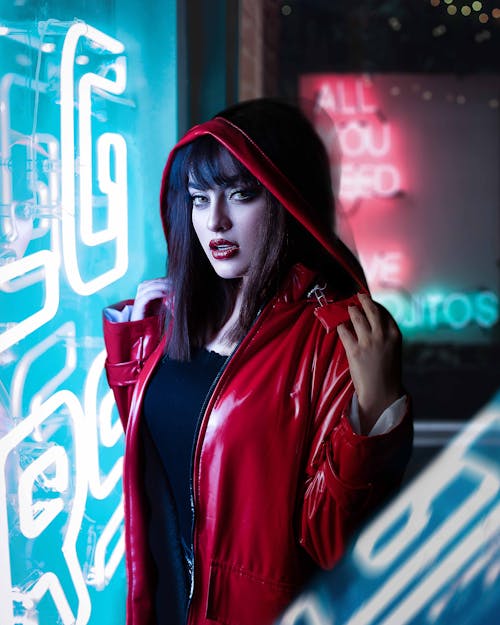 Woman Wearing Red Leather Jacket Standing Near Neon Light Wall