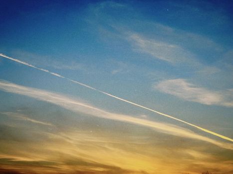 Beautiful sunset sky with striking contrails over Konaev, Almaty Region, Kazakhstan.