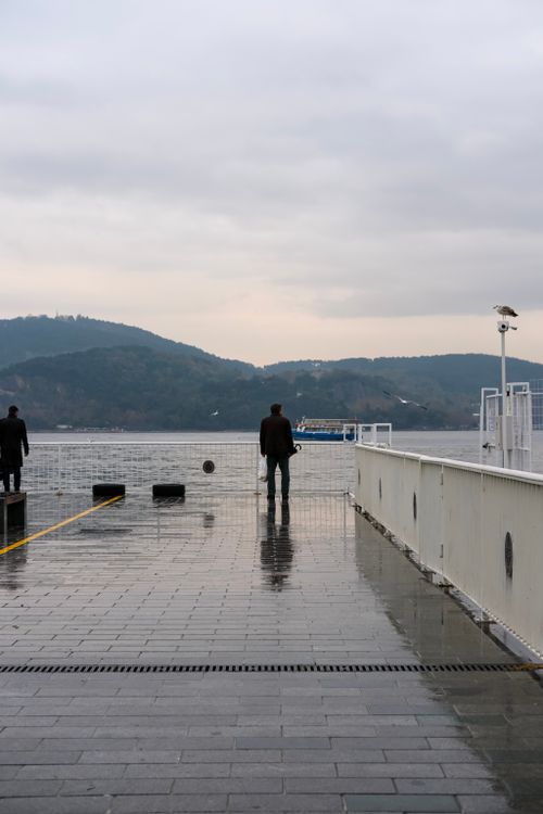 Free A lone figure on a rainy İstanbul dock, capturing a serene and moody waterfront view. Stock Photo