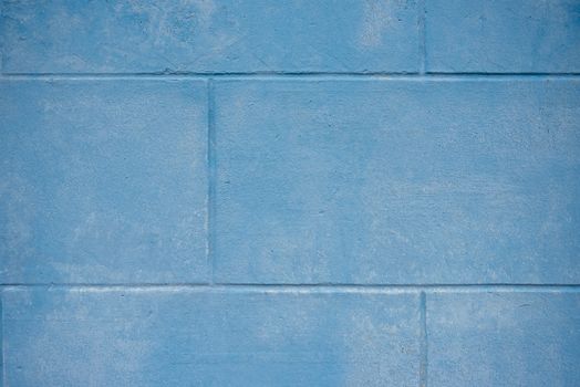A close-up view of a textured blue painted concrete wall.