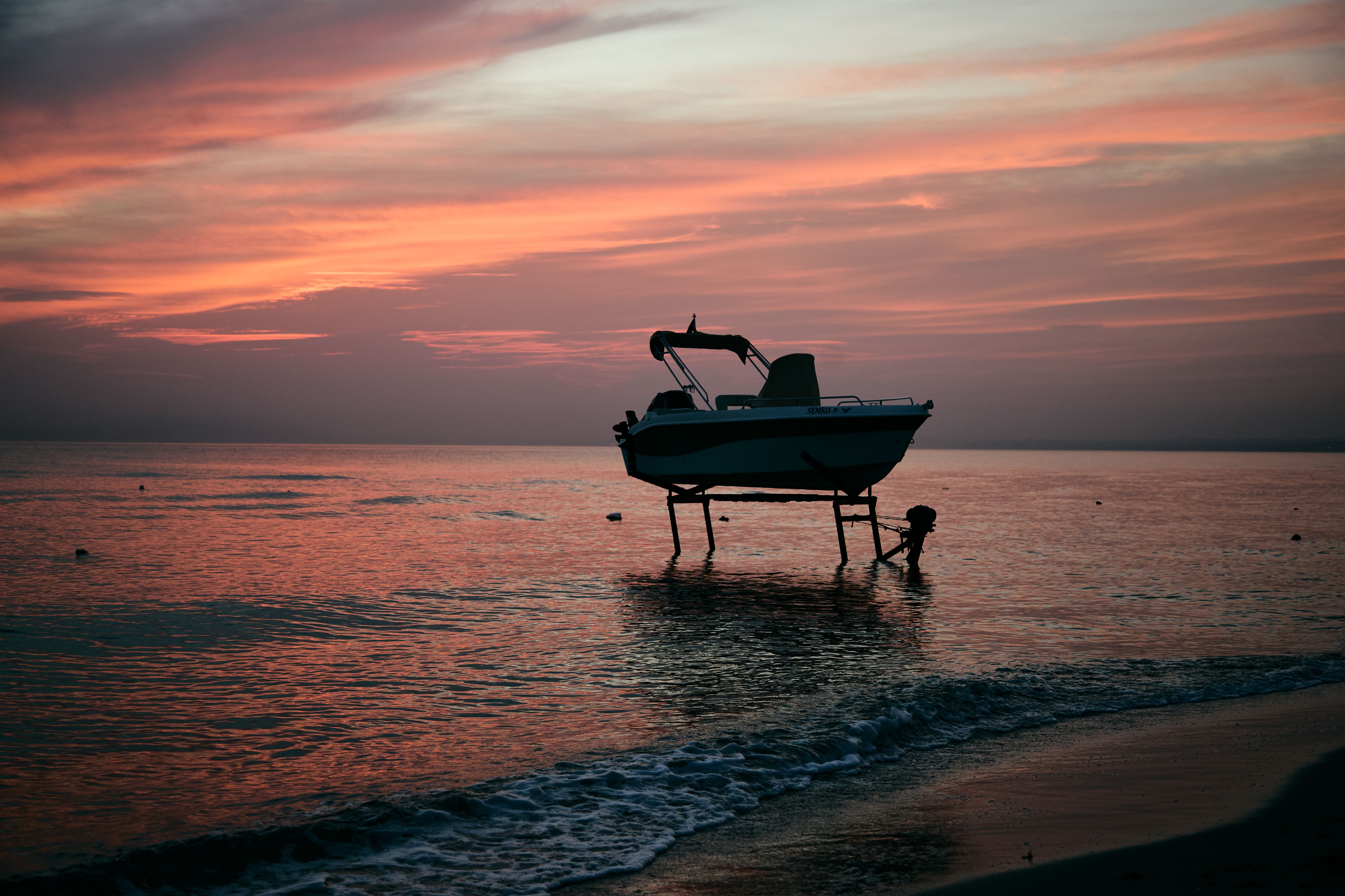 Serene Boat Silhouette at Sunset Beach · Free Stock Photo