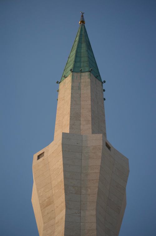 Free Close-up view of a modern mosque minaret reaching into a clear blue sky, architectural detail. Stock Photo