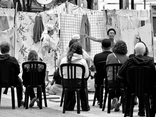 Free Street theater performance captured in black and white with an attentive audience outdoors. Stock Photo