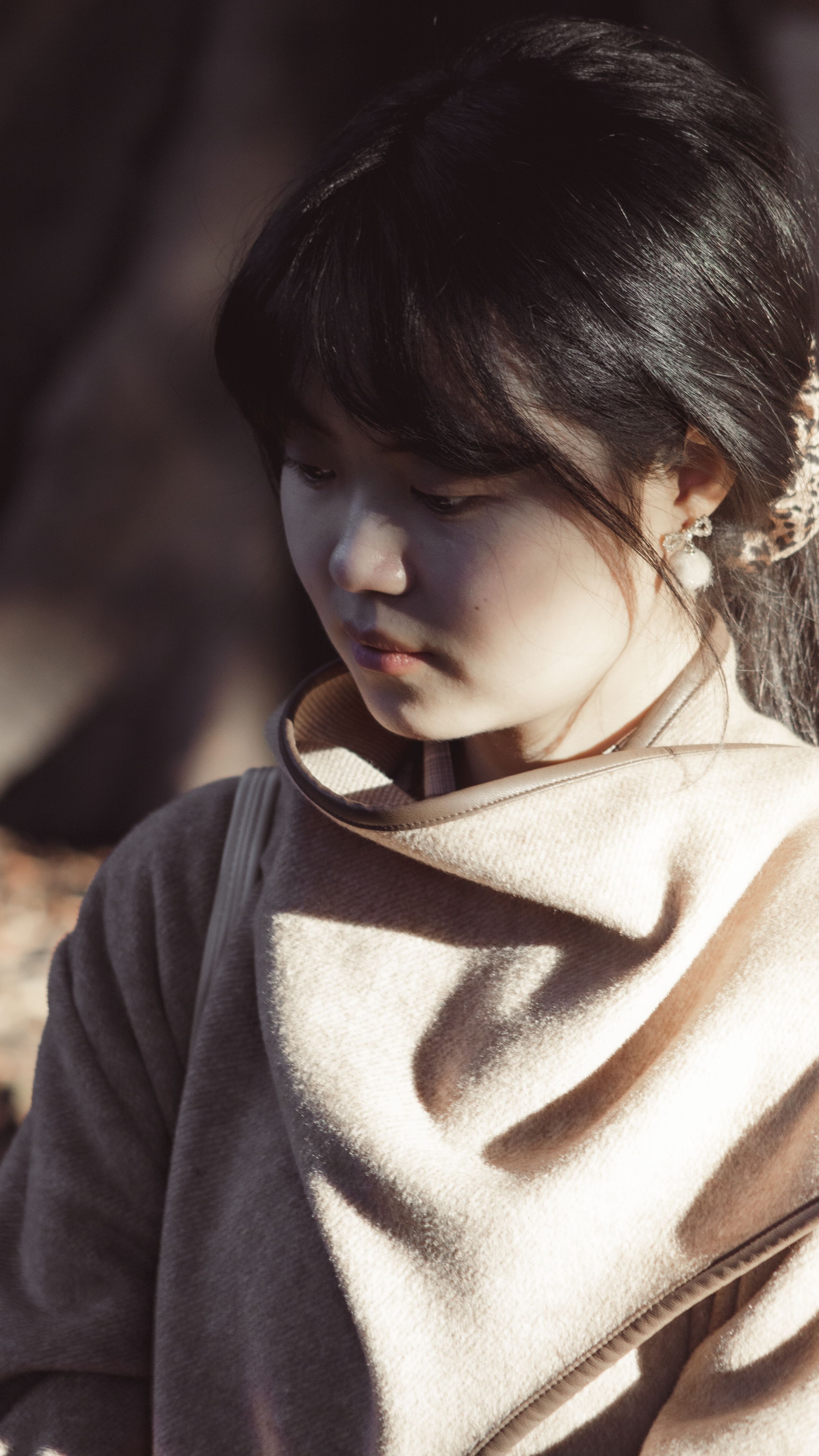 Portrait of a woman outdoors in soft lighting, capturing a serene and contemplative moment.