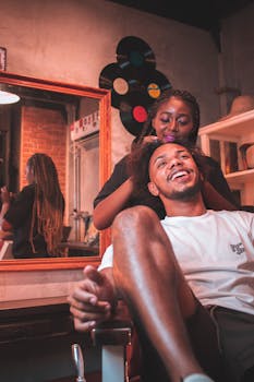 A happy man enjoying his time at a salon while a skilled stylist works on his hair.