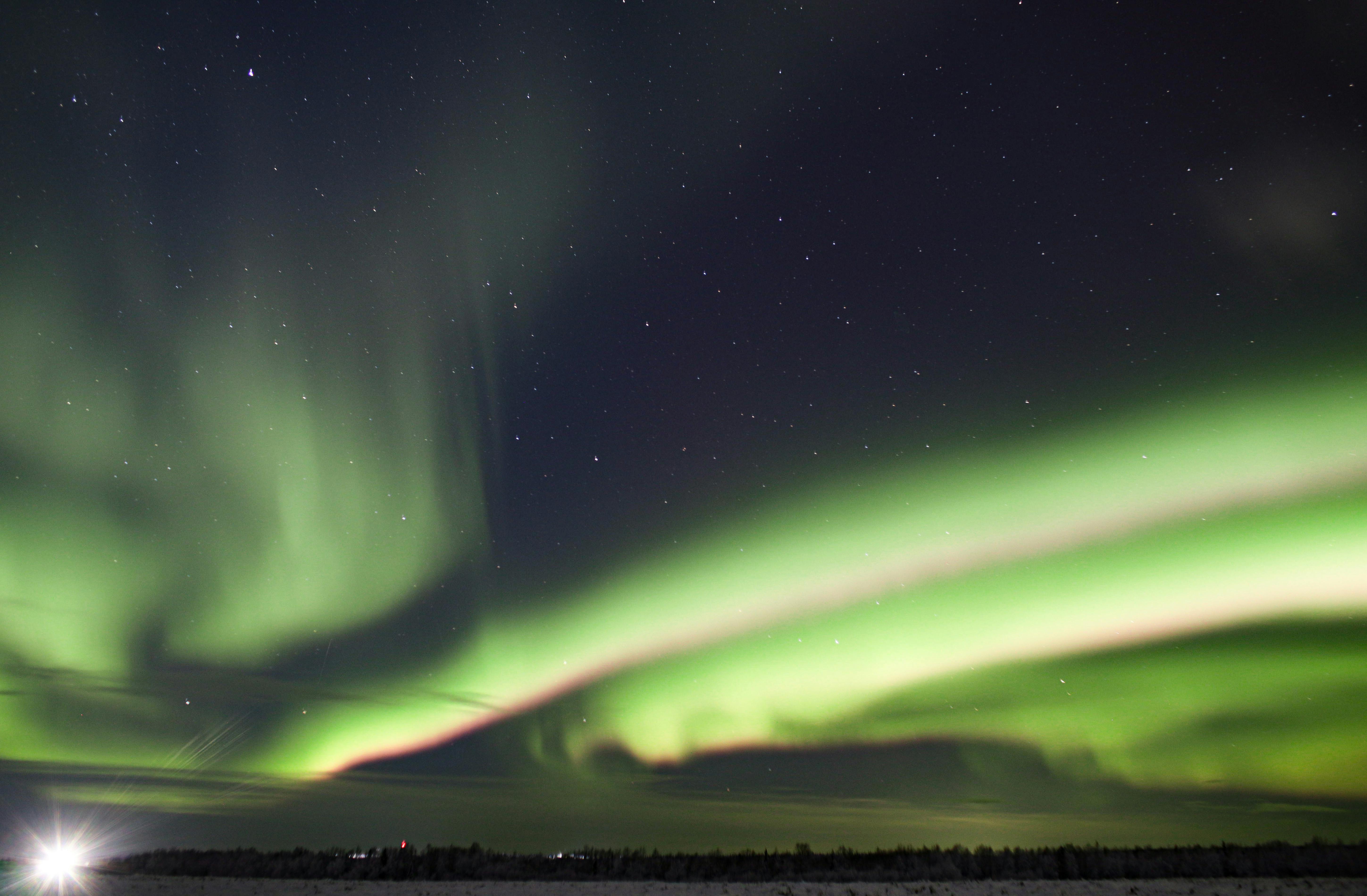 Captivating view of aurora borealis dancing across a starry night sky.
