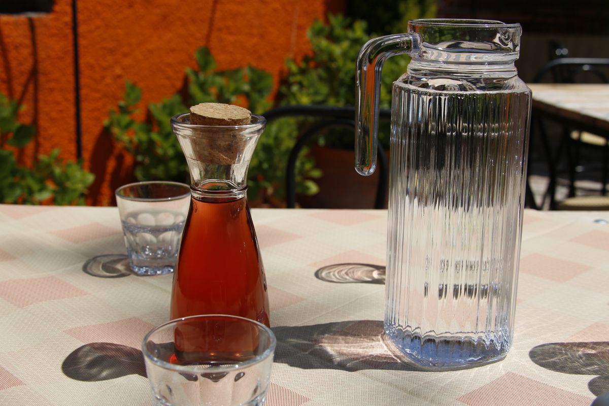 Mesa exterior soleada puesta con cristalería elegante