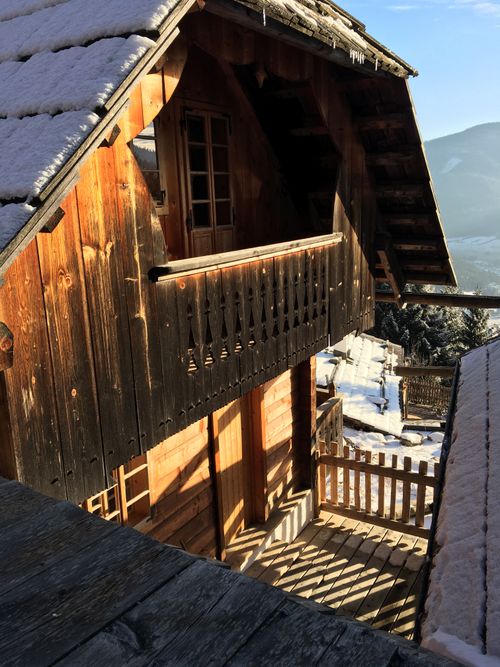 Free Charming wooden chalet in snowy alpine setting under bright sunlight, perfect for winter travel scenes. Stock Photo