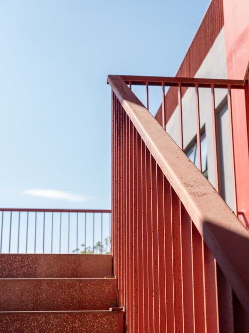 Free Artistic view of red stair railing against a bright blue sky. Stock Photo