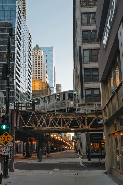 Free A Chicago elevated train travels between tall buildings during daytime, capturing urban architecture. Stock Photo