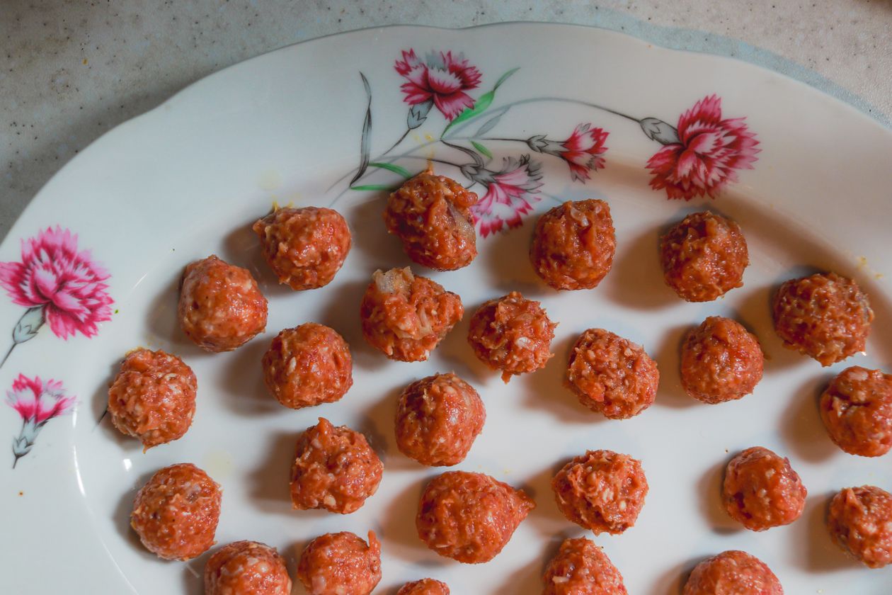 Raw chicken meatballs shaped and arranged ready for the oven