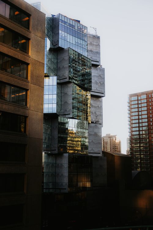 Free Stunning view of abstract architecture combining glass and concrete in cityscape at sunrise. Stock Photo