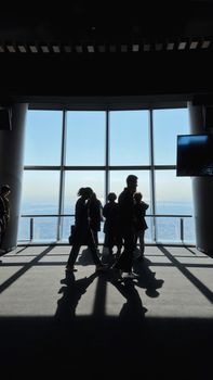 Visitors silhouetted against the panoramic view from Tokyo Skytree's observation deck.