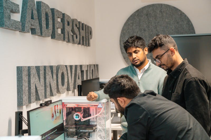 A group of men looking at a computer in an innovative workspace