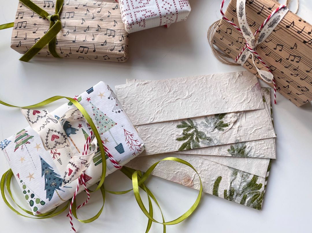 Beautifully wrapped holiday gifts with nature and music-themed designs, perfect for Christmas.