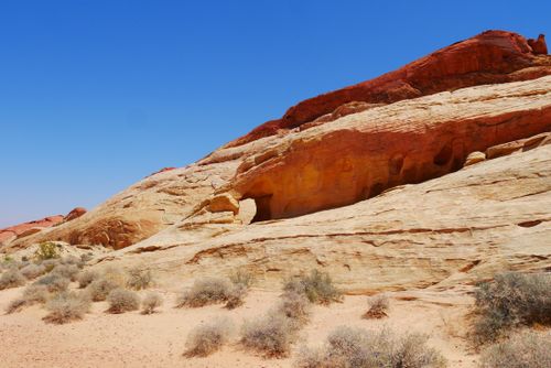Free A captivating view of desert rock formations with vibrant colors beneath a clear blue sky. Stock Photo