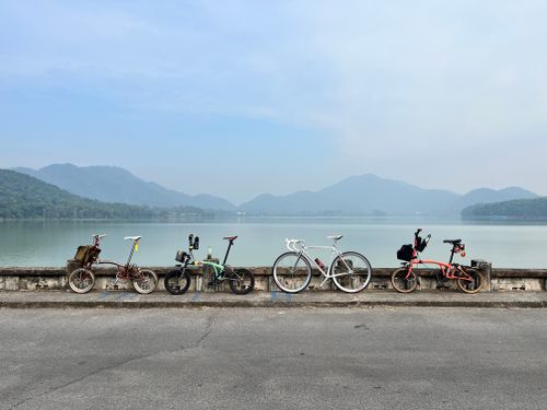 Free A serene scene of bicycles lined up by a lake with misty hills in Vietnam. Stock Photo