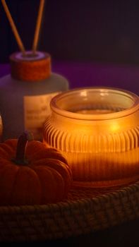 Warm candlelit setup with a pumpkin and cozy autumn vibes.