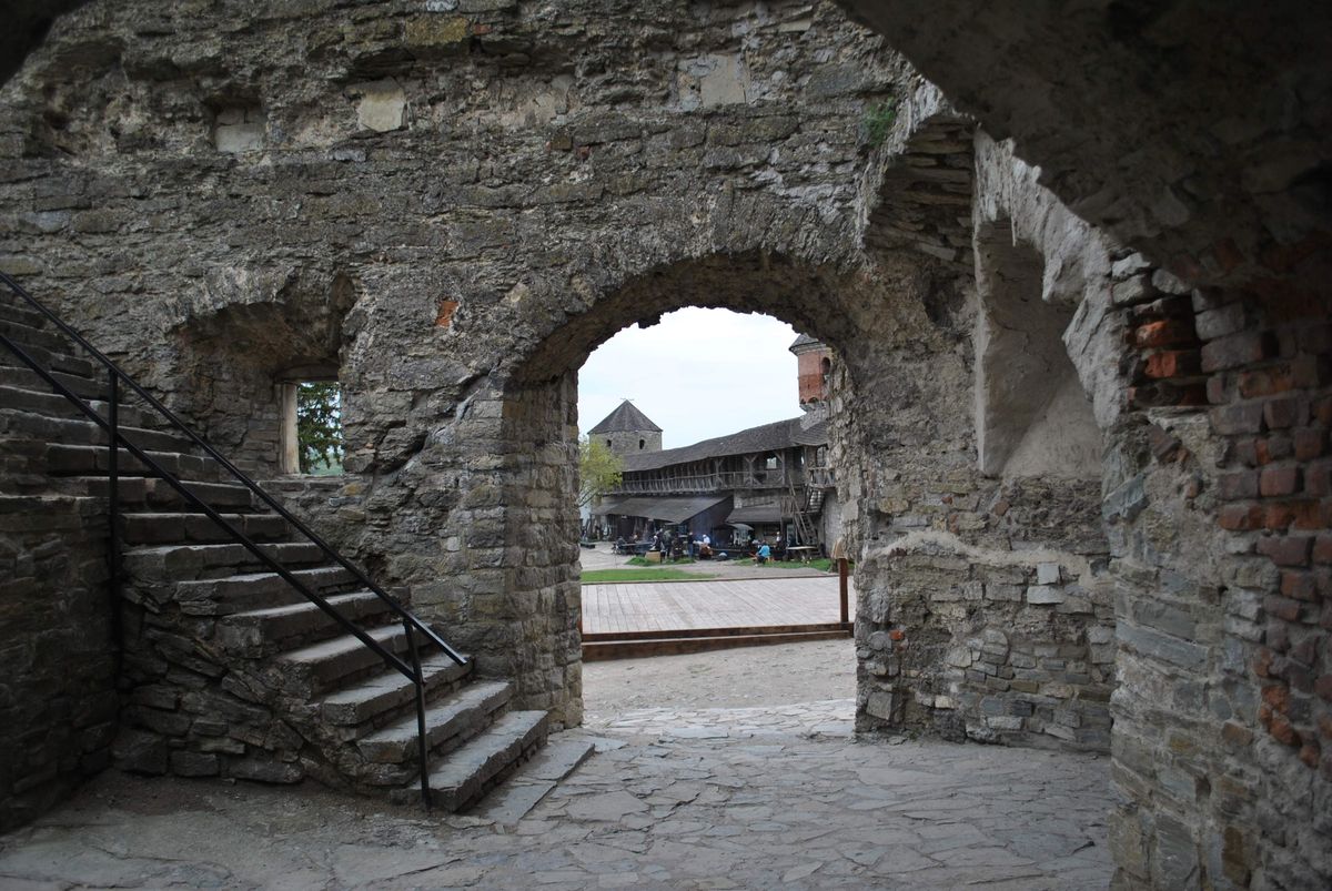 Arcadă de piatră spre o curte medievală