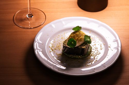 Free A beautifully plated gourmet dish with a glass of wine in a Tokyo restaurant setting, showcasing fine dining elegance. Stock Photo