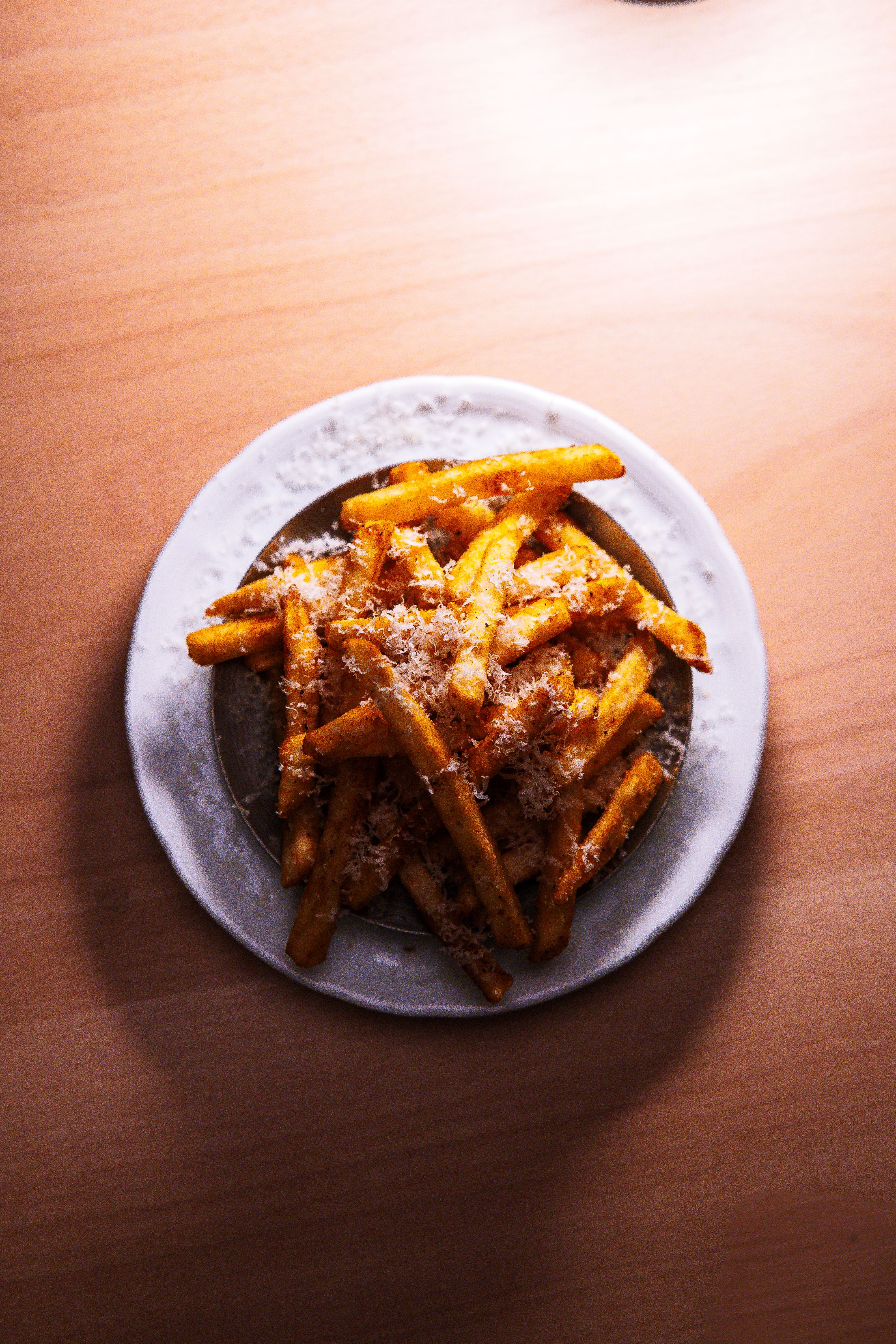 Deliciously seasoned French fries topped with grated Parmesan cheese, perfect for savory snacking.