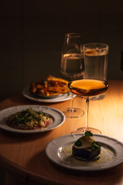 A Southern Comfort Manhattan in a coupe glass, deep amber-red in color, garnished with a brandied cherry and an orange twist resting on the rim.