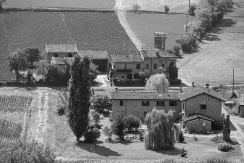 Free Black and white aerial photo of a rustic farmhouse surrounded by fields. Stock Photo