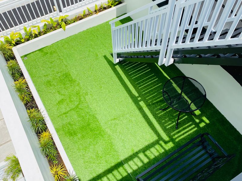 Terraza con césped artificial y mobiliario moderno