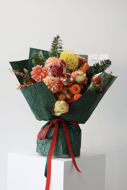 Free A colorful autumn bouquet with roses, dahlias, and greens wrapped in textured paper. Stock Photo
