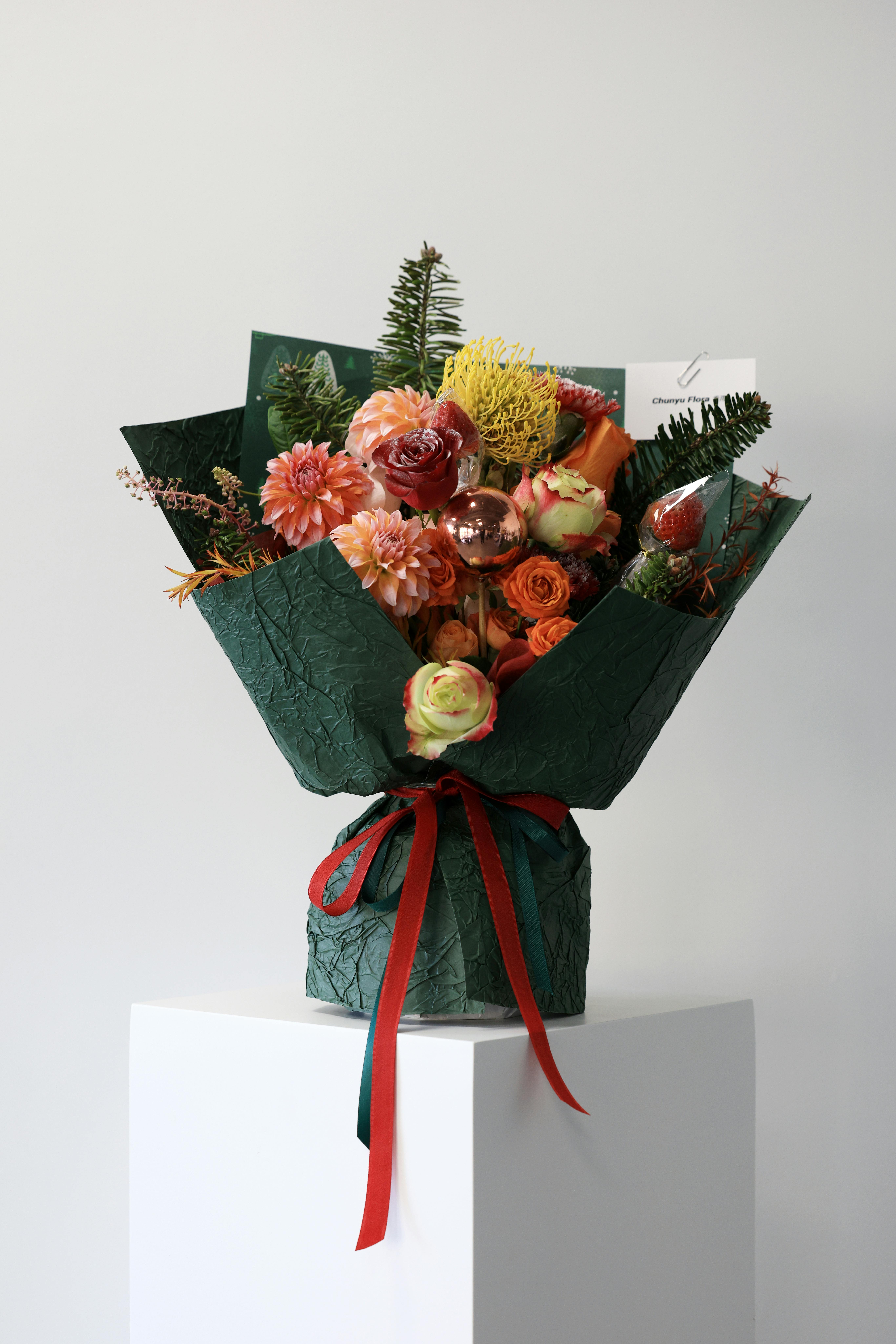 Colorful flower bouquet elegantly wrapped in dark green paper, perfect for celebrations.