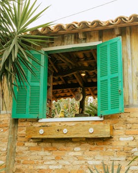 Charming vintage-style brick house with vibrant green shutters in São Paulo, Brazil.