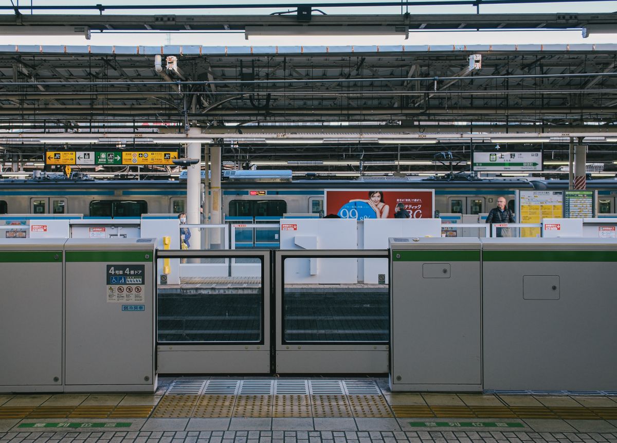 Busy Japanese train station platform with commuters boarding