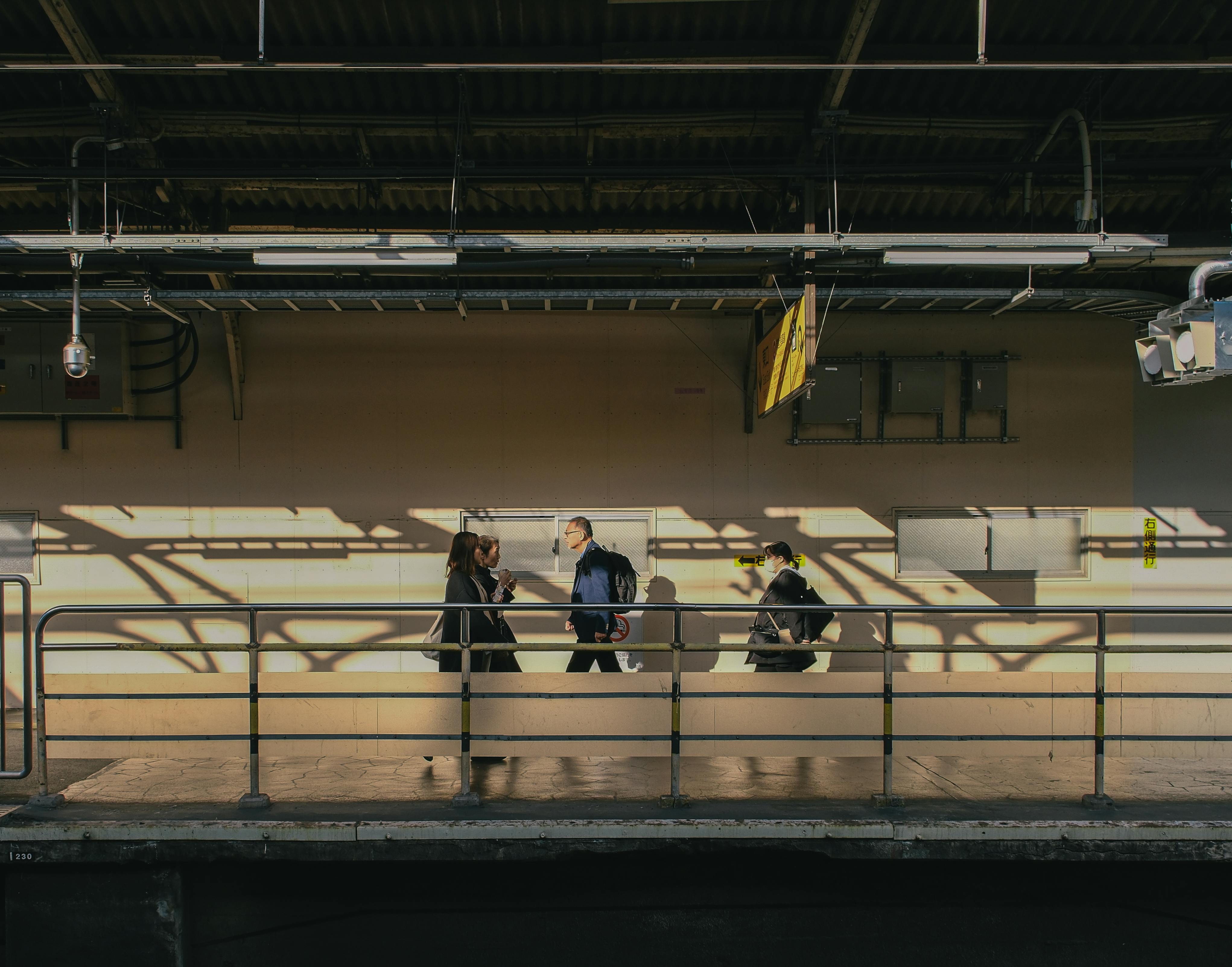 Commuters on a sunlit train platform