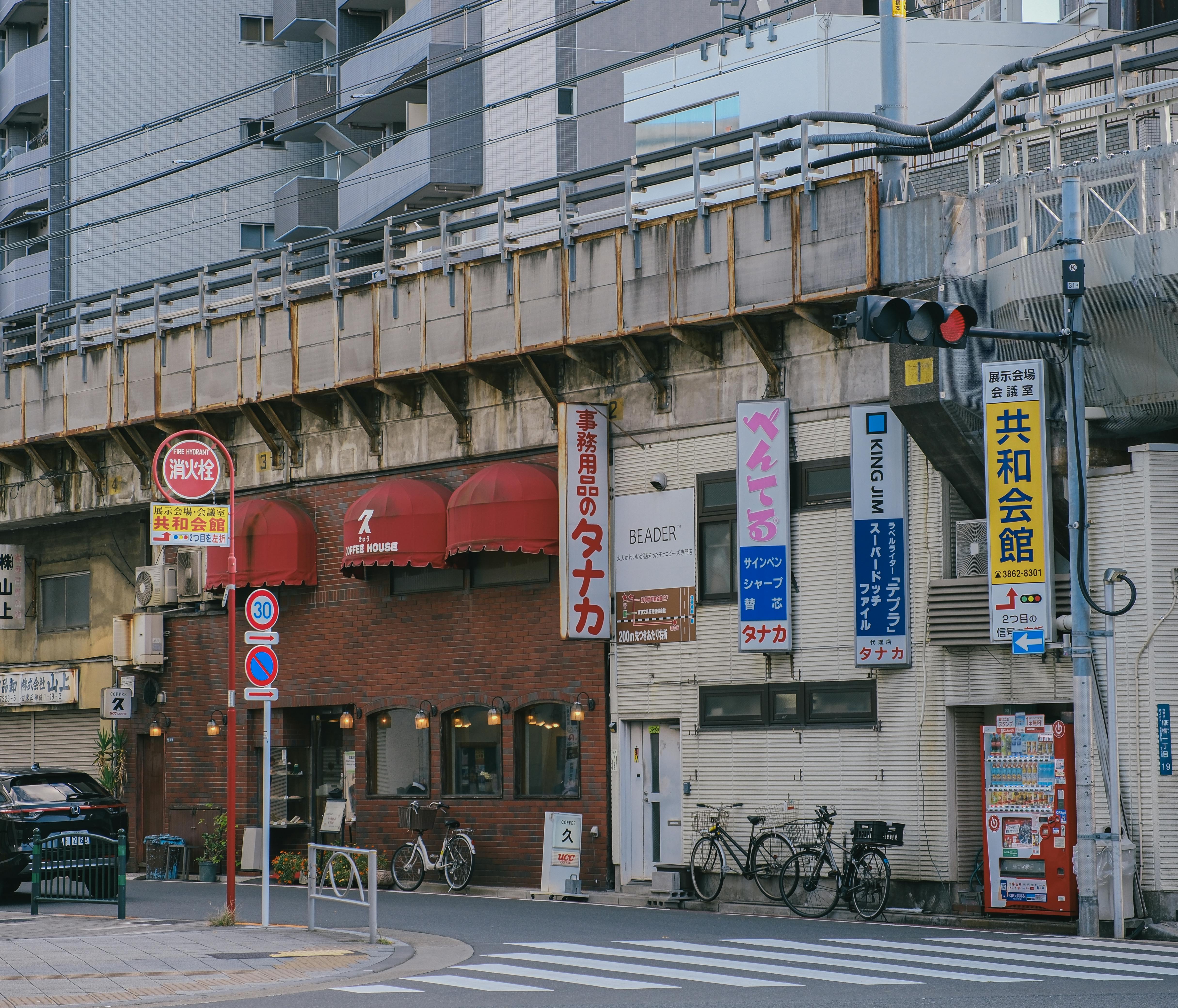 Gratis Gadescene i Japan med lokale virksomheder og reklamer under en elevatorjernbane. Lagerfoto
