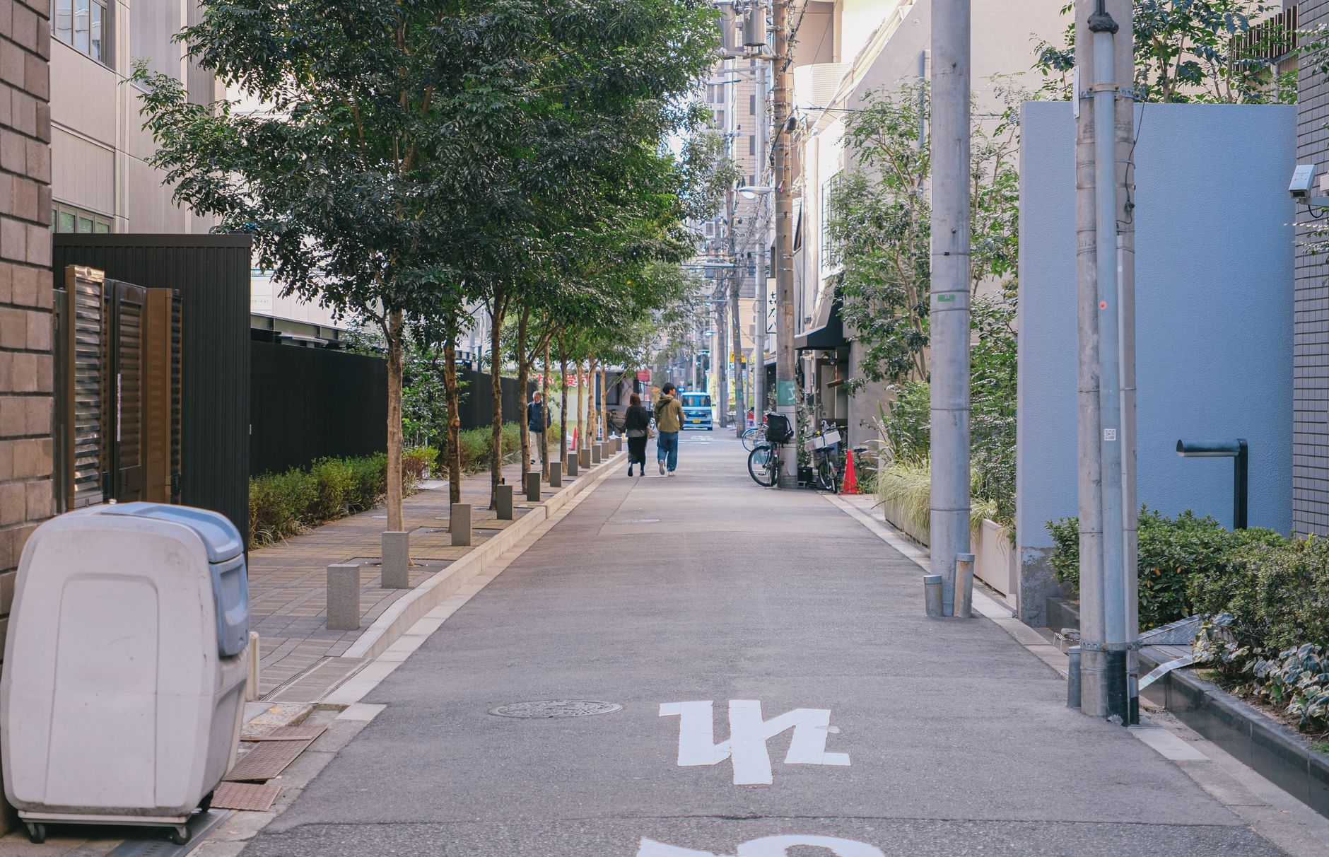 A peaceful urban alley with trees and pedestrians, ideal for city life concepts.