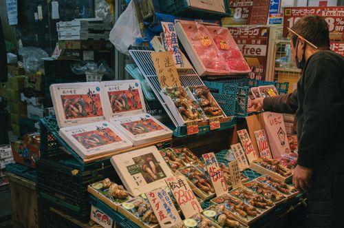 Free A vibrant scene of a Japanese seafood vendor displaying fresh produce at a local market. Stock Photo