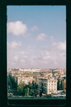 Captivating cityscape seen through a window frame, highlighting urban architecture under a sunny sky.