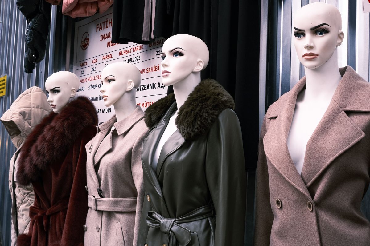 A row of long coats displayed outside a shop front