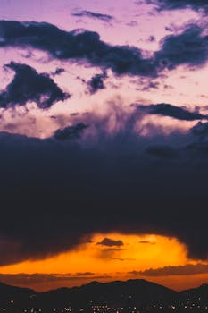 A breathtaking sunset with vivid orange and purple skies casting shadows over a distant mountain range.