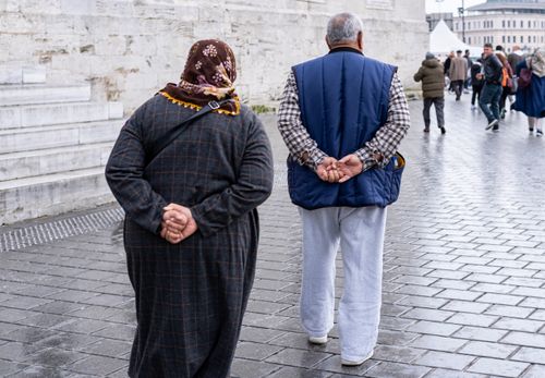 Free Elderly couple walks along wet streets of Istanbul, Türkiye, showcasing a typical rainy day. Stock Photo