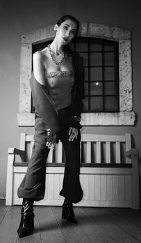 Stylish black and white portrait of a woman posing in an urban setting with bold fashion elements.