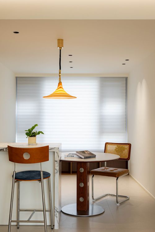 Free Sleek dining area featuring modern furniture and warm lighting. Stock Photo