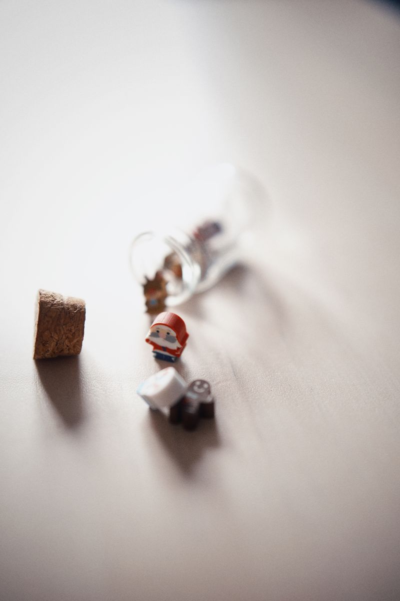 Scattered figurines next to glass bottle representing Zombie Party world building and BaiChaoHui IP universe