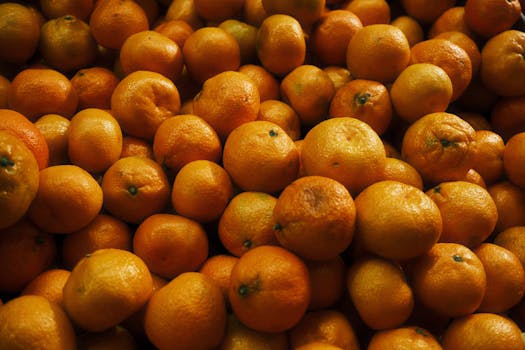 A pile of fresh oranges with vibrant colors captured under natural light.